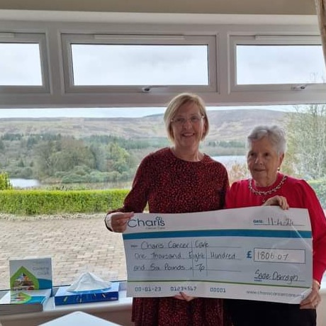 An image of Sadie presenting a cheque to Imelda at the centre